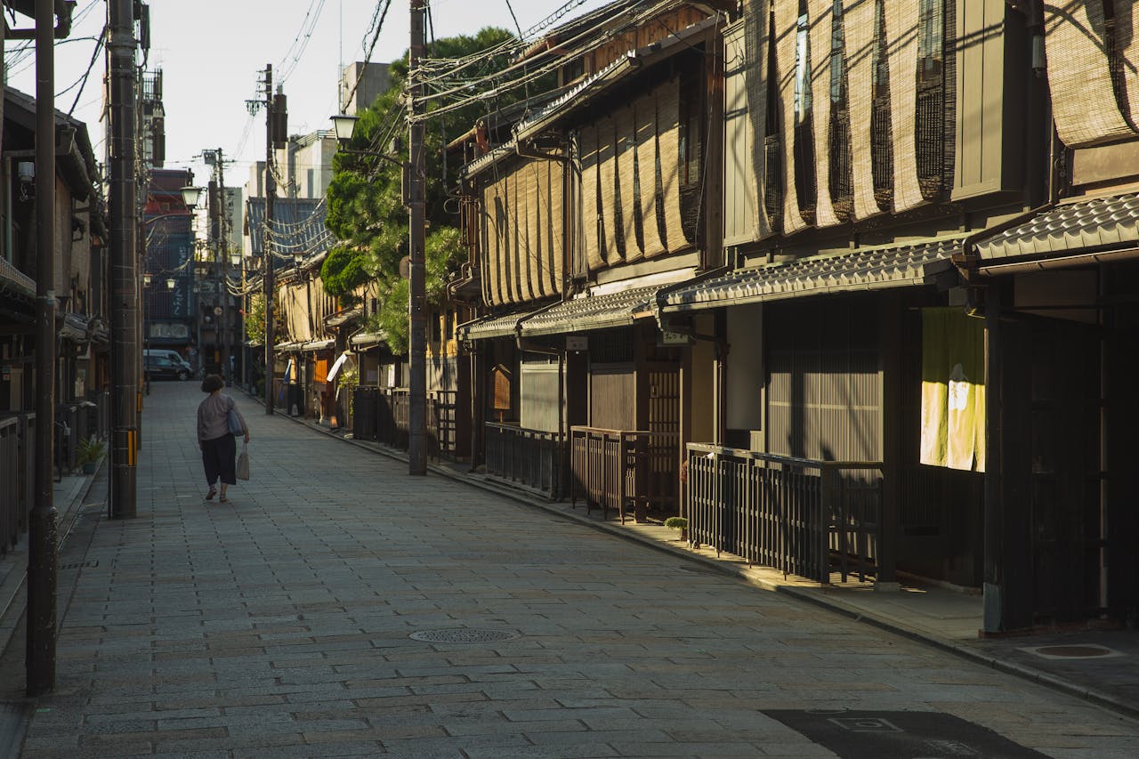 Unrecognizable woman walking near traditional houses in Japan